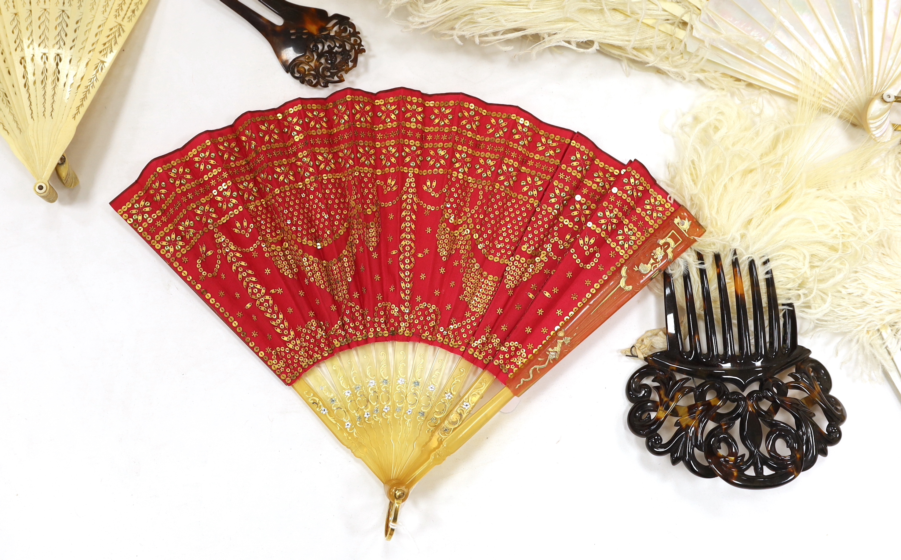 A Regency sequin and horn fan, a bone brise fan, a large white feather fan and a similar miniature fan and hat ornament two hair combs, etc